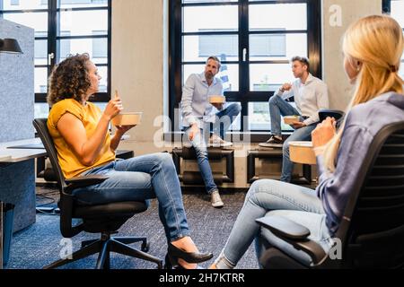 Donne d'affari che pranzano con i colleghi in ufficio Foto Stock