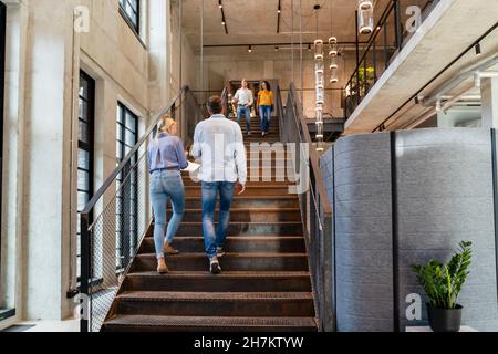 Colleghi che camminano su una scala in ufficio Foto Stock