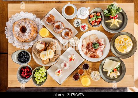 Studio shot di tavolo per la colazione riempito con vari dessert, frutta e verdura Foto Stock