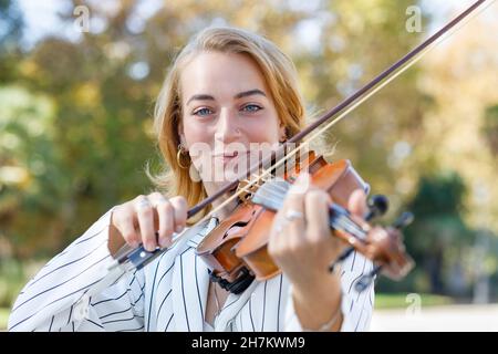 Giovane musicista sorridente che suona il violino Foto Stock