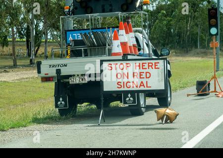 Da Townsville a Mackay Highway, Queensland, Australia - Novembre 2021: Fermati qui sul segnale rosso sul cartello stradale dietro un camion dei lavoratori edili Foto Stock