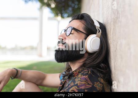 Uomo disabili sorridente con libro che guarda via nel parco pubblico Foto Stock