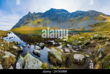Riva rocciosa del lago di Herzsee nelle Alpi Otztal durante l'autunno Foto Stock