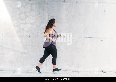 Sportivo giovane e di grandi dimensioni che corre sul sentiero Foto Stock