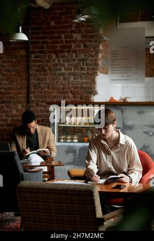 Gli studenti trascorrono il pranzo in un moderno caffè Foto Stock