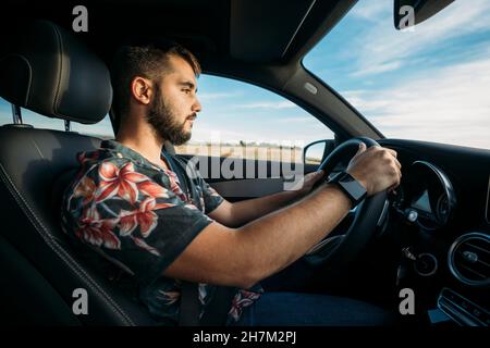 Vettura di guida del giovane uomo bearded Foto Stock