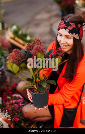 Donna sorridente azienda pianta in vaso Foto Stock