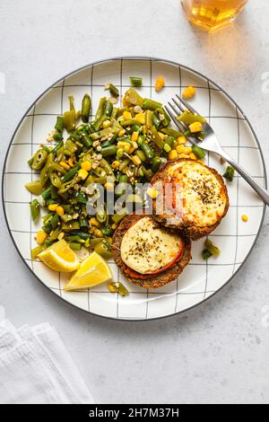 Forchetta e coltello per piatto di hamburger con insalata sul tavolo Foto Stock