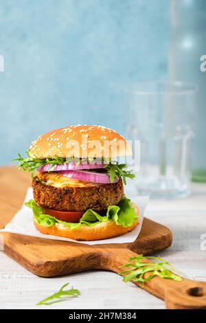 Panino al hamburger con verdure servite nel piatto sul tavolo Foto Stock