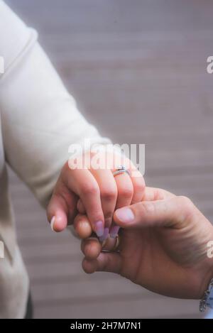 Uomo che tiene la mano di una donna con un anello di nozze sul suo dito Foto Stock