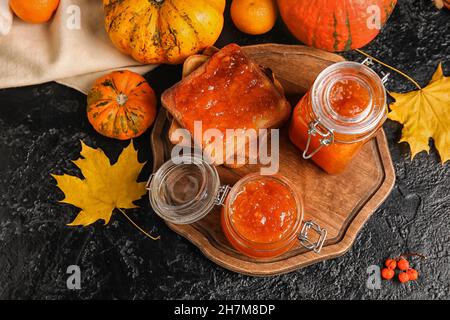 Vasetti di marmellata di zucca dolce e toast su sfondo nero Foto Stock