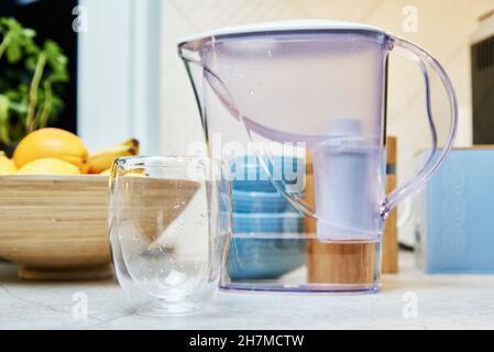 Svuotare il bicchiere e il filtro dell'acqua sul tavolo in cucina Foto Stock