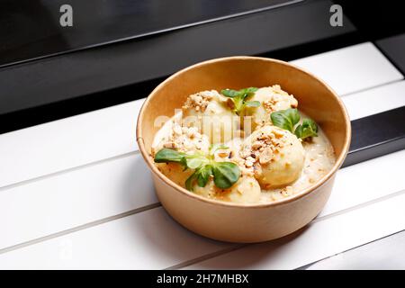 Gnocchi di patate, gnocchi di patate con salsa di pomodoro e parmigiano. Takeaway, scatola di dieta. Appetitoso piatto pronto all'uso servito in un recipiente monouso Foto Stock