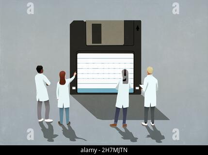Scienziati in camici di laboratorio che guardano il floppy disk Foto Stock