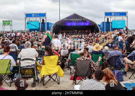 Una grande folla di persone che guardano un'orchestra si esibiscono al Captain Cook Wharf di Auckland, Nuova Zelanda Foto Stock