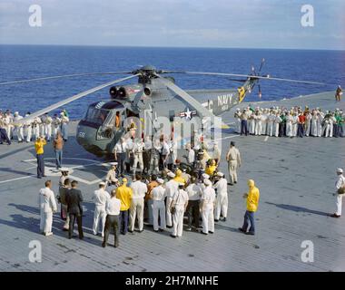(18 dic. 1965) --- l'equipaggio del semaforo spaziale Gemini-7, gli astronauti Frank Borman, pilota di comando, e James A. Lovell Jr., pilota, arrivano a bordo della portaerei USS Wasp. Gli astronauti sono stati prelevati dall'oceano, a seguito di un riuscito smashdown, da elicottero di recupero e volati al vettore per iniziare le debriefing medico e tecnico dopo il volo Foto Stock