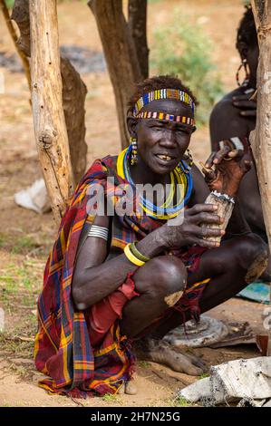 Donne vestite tradizionali che fumano, tribù Jiye, Eastern Equatoria state, South Sudan Foto Stock