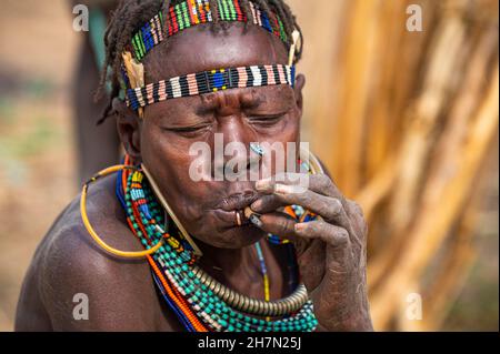 Donne vestite tradizionali che fumano, tribù Jiye, Eastern Equatoria state, South Sudan Foto Stock