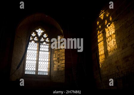 La luce del sole di fine autunno attraverso la finestra ovest, la chiesa di St. Gregory`s, Tredington, Warwickshire, Inghilterra, REGNO UNITO Foto Stock