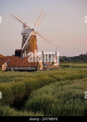 Guardando oltre i letti di canna di crepuscolo di Cley Marshes al mulino a vento / Towermill di Cley, North Norfolk Heritage Coast villaggio di Cley accanto al Mare Inghilterra Foto Stock