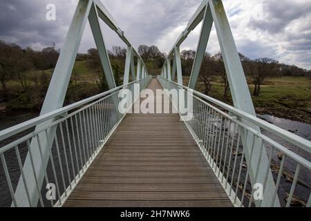 Ponte pedonale Dinkley che attraversa il fiume ribble vicino al verde hurst. Passerella metallica simmetrica Foto Stock