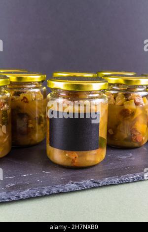 Chutney dopo la zucchina è cresciuto nel midollo. Diversi vasi sfondo nero ritratto nero etichetta copyspace. Foto Stock