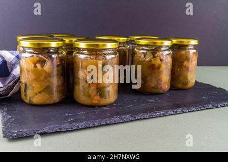 Chutney dopo la zucchina è cresciuto nel midollo. Diversi vasi nero sfondo scuro paesaggio, copyspace. Foto Stock