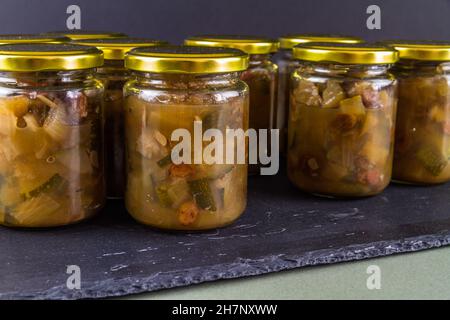 Chutney dopo la zucchina è cresciuto nel midollo. Diversi vasi sfondo nero scuro paesaggio Foto Stock