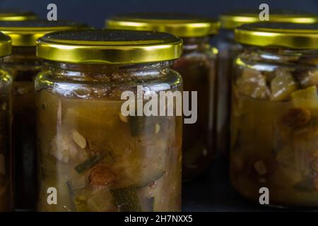 Chutney dopo la zucchina è cresciuto nel midollo. Diversi vasi sfondo nero scuro paesaggio. Foto Stock