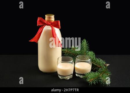 Eggnog fatto in casa in bottiglia e due bicchieri con biscotti di Natale Foto Stock