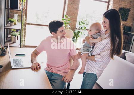 Foto di padre freelance pagare tempo libero attenzione famiglia indossare abiti casual in confortevole casa appartamento al coperto Foto Stock