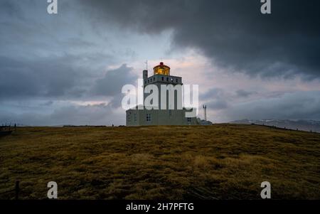 Dyrholaey faro al tramonto. La stazione di luce a Dyrholaey è stata fondata nel 1910, vicino al villaggio di Vik, sulla punta meridionale dell'Islanda. Foto Stock