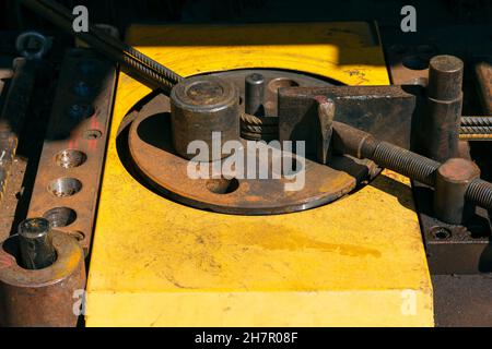 Macchina piegatrice per barrette nel sito. Preparazione di pezzi da aste di armatura per lavori in calcestruzzo. Macchina curvatrice per armatura nella costruzione Foto Stock