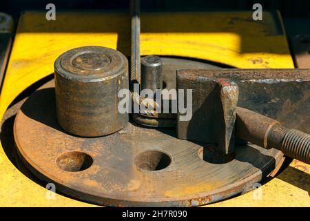 Macchina piegatrice per barrette nel sito. Preparazione di pezzi da aste di armatura per lavori in calcestruzzo. Macchina curvatrice per armatura nella costruzione Foto Stock