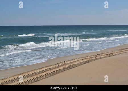 Le profonde piste degli pneumatici sono evidenti nella sabbia soffice della spiaggia. Foto Stock