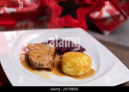 Arrosto di maiale con gnocchi di patate e cavolo rosso. Cibo fatto in casa, cena di natale Foto Stock