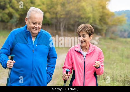 Felice coppia trekking senior insieme divertirsi all'aperto nei boschi - Focus on woman face Foto Stock