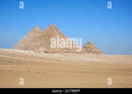 Vista su Khafre, Menkaure e piramidi delle Regine dal deserto. Numerosi cavalieri di cavalli e cammelli nel telaio. Foto Stock