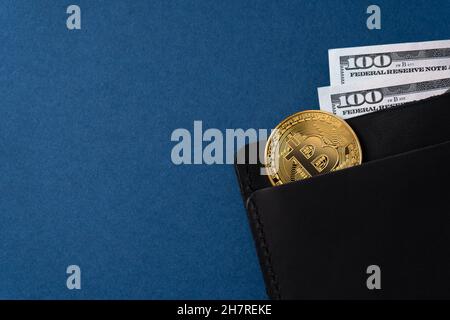 Denaro e criptovaluta in un portafoglio da uomo. Concetto di denaro virtuale in realtà su sfondo blu. Spazio di copia Foto Stock