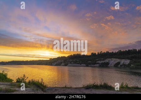 Tramonto nel cielo nuvoloso sopra la cava di Pugorevsky. Vsevolozhsk. Regione di Leningrad. Foto Stock