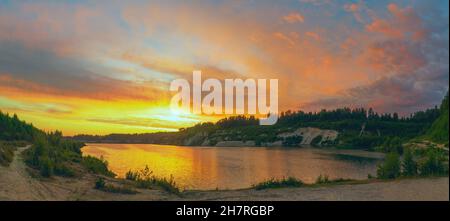 Tramonto nel cielo nuvoloso sopra la cava di Pugorevsky. Vsevolozhsk. Regione di Leningrad. Foto Stock