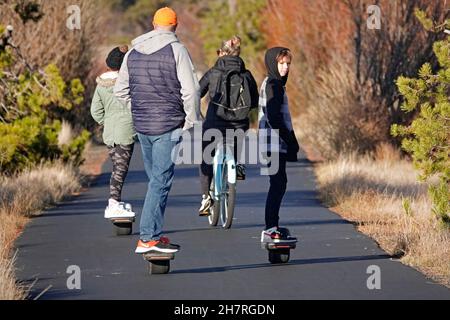 Un hoverboards a conduzione familiare conduce un sentiero per passeggiate a piedi e in bicicletta nella comunità di Sunriver, Oregon. Foto Stock