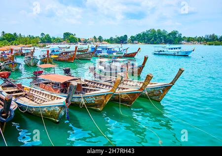 AO NANG, THAILANDIA - 26 APRILE 2019: Le numerose vecchie barche a coda lunga in legno, decorate con nastri colorati e fiori, sono ancorate al Molo di Ao Nammao, Foto Stock