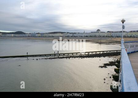 Una vista dal molo che si affaccia sulla grandiosa baia di Llandudno, con hotel tipicamente dipinti a pastello che fiancheggiano la passeggiata. Foto Stock