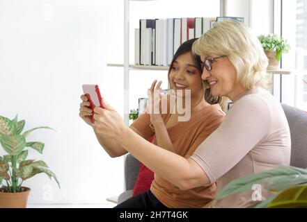 Felice famiglia biraciale onda mano al tablet digitale, videochiamata online con un amico o cugino. Tecnologia dell'informazione del Internet, distancin sociale Foto Stock