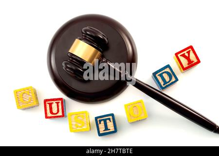 Decisione legale per quanto riguarda la custodia dei bambini dopo un tema di concetto di divorzio con primo piano su un gavel di legno e bambini blocchi di legno giocattolo con lettere i Foto Stock