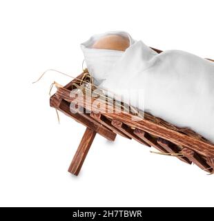 Mangiatoia in legno con manichino del bambino su sfondo bianco. Concetto di storia di Natale Foto Stock