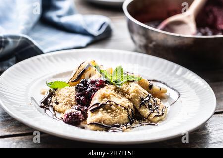 Pierogi appena fatti serviti con salsa di frutti di bosco e foglie di menta in cima. Foto Stock