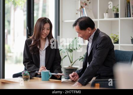 Amichevole avvocato o consulente finanziario in tuta consulenza anziano uomo, sorridente intermediario di investimento o lavoratore bancario che fanno prestito offerta, dando consulenza legale Foto Stock