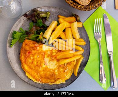 Porzione di omelette gourmet con patate fritte Foto Stock